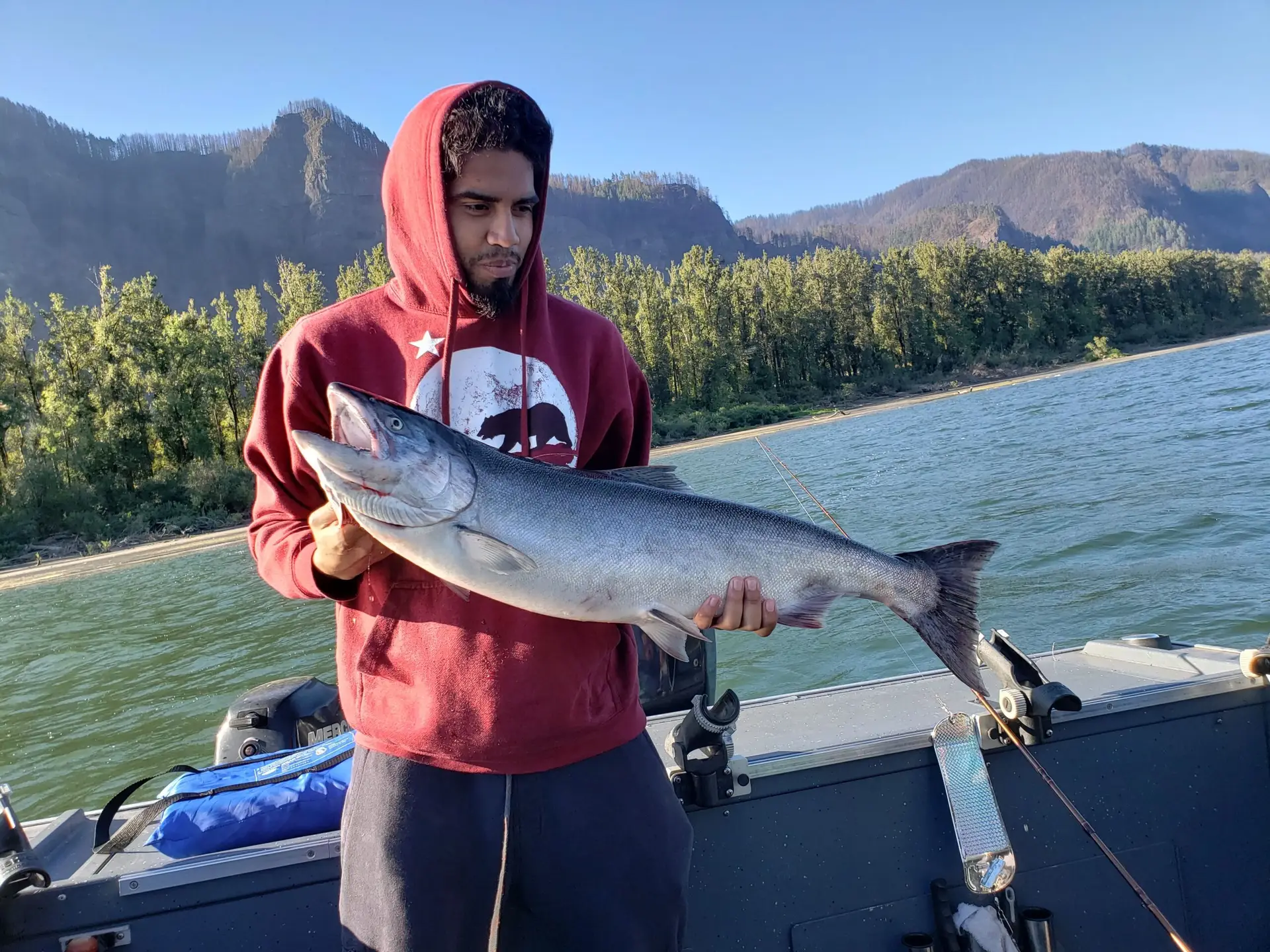 Guy in red hoodie holding salmon