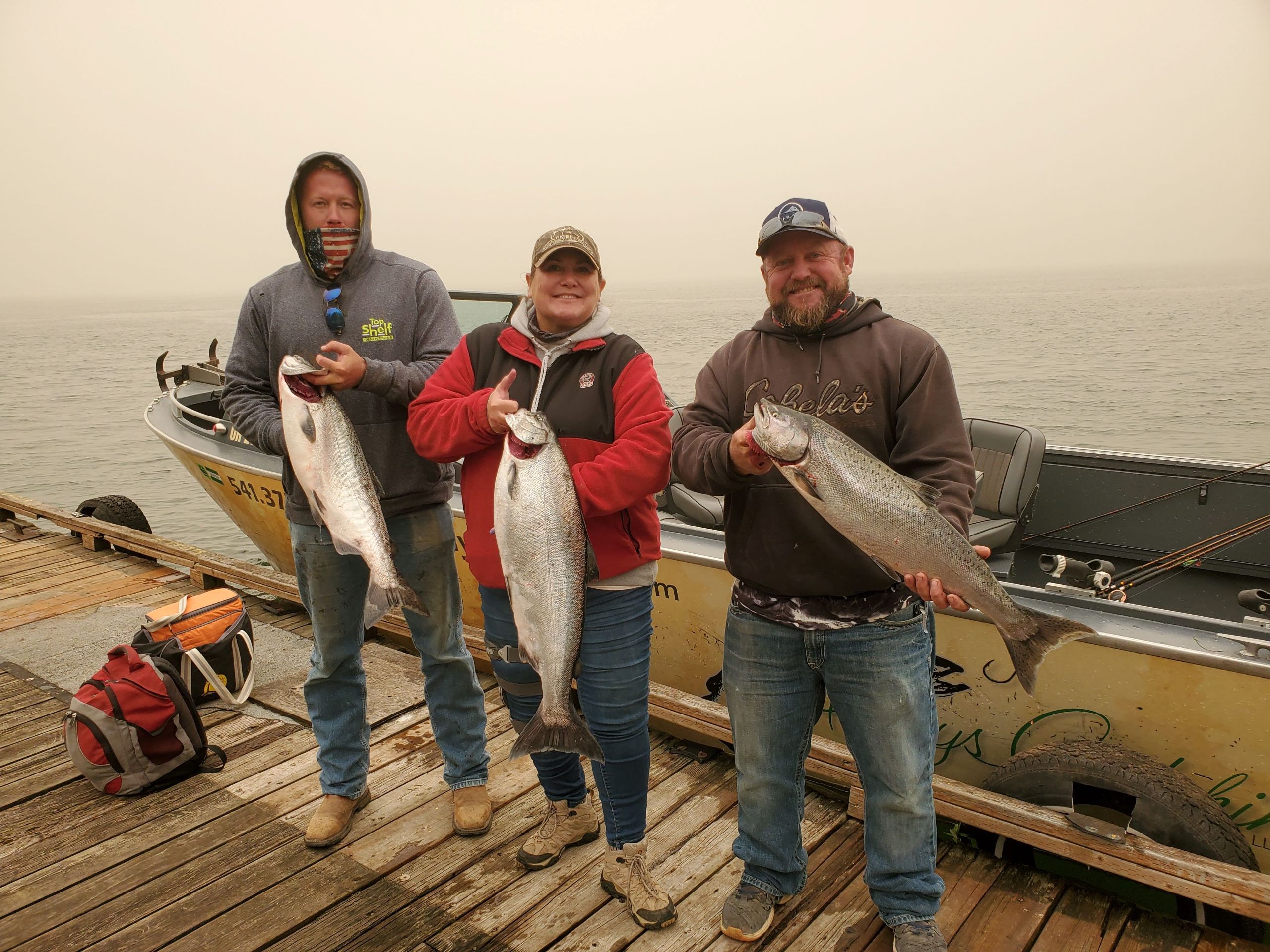 3 people holding 3 salmon during Eagle Creek Fire of 2017
