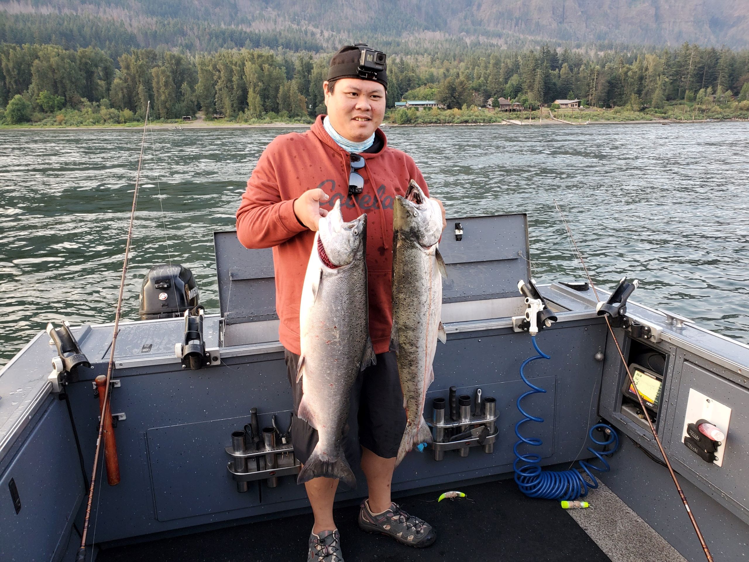 very happy person holding 2 salmon