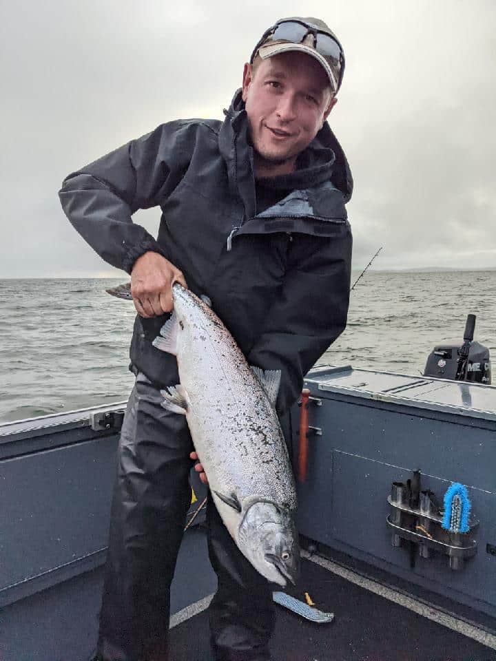 Brandon holding a salmon he caught in the Pacific ocean