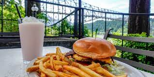 Bridgeside burger and fries with a shake on outside table with Bridge of the Gods in the background