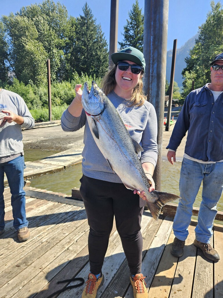 Girl holding Fall Chinook Salmon on a dock